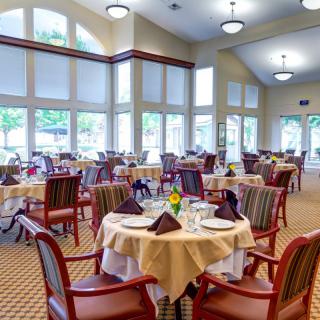 A well-lit dining area with neatly arranged tables and chairs.