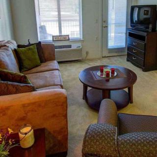 A cozy living room featuring a sofa, coffee table, and television.