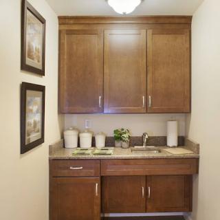 A cozy bathroom vanity area featuring wooden cabinets, a sink, and decorative art.