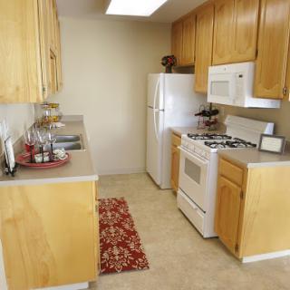 A cozy kitchen featuring light wooden cabinets and essential appliances, perfect for cooking and dining.