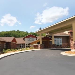 A welcoming residential building set against a lush, green backdrop.