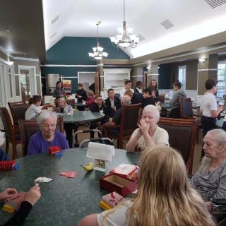 A group of people socializing and playing card games in a communal room.
