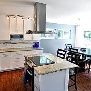 A modern kitchen with an island and adjacent dining area.