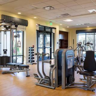 A modern gym with various exercise equipment and a spacious workout area.