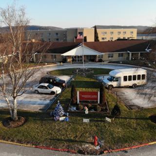 Aerial view of a facility with vehicles parked in front and holiday decorations.