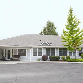 A single-story building with a landscaped exterior and surrounding trees.