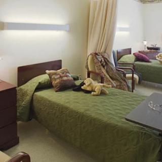 A clean and well-organized hospital room with two beds and medical equipment.