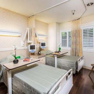 A clean and organized hospital room with two patient beds, medical equipment, and a serene atmosphere.