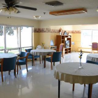 A dining area with multiple tables and chairs, featuring large windows.