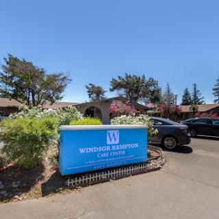 Entrance sign of a facility with clear blue skies and surrounding vegetation.