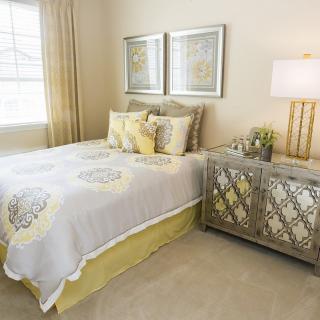 A cozy bedroom with elegant decor, featuring a neatly made bed, stylish nightstand, and warm lighting.