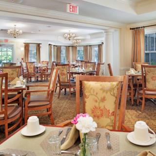 An elegant dining room interior with neatly arranged tables and chairs, adorned with decorative elements.
