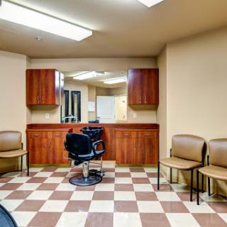 A minimalistic barbershop interior featuring a central barber chair and waiting area.