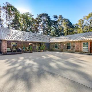 A beautiful modern residential property featuring a spacious courtyard surrounded by trees.