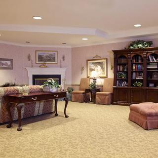 A cozy living room with a fireplace, bookshelves, and comfortable seating.