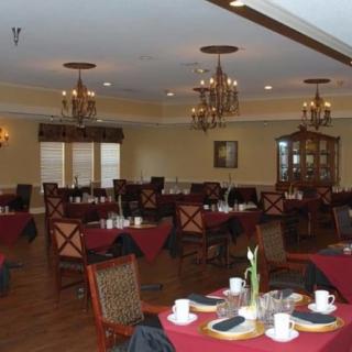 A cozy restaurant dining room with elegant chandeliers and neatly arranged tables.