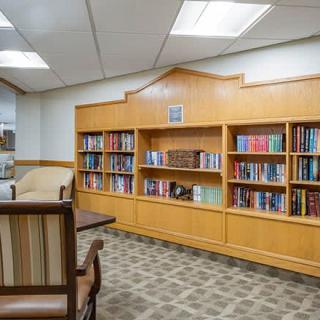 A cozy library reading area with bookshelves and comfortable seating.