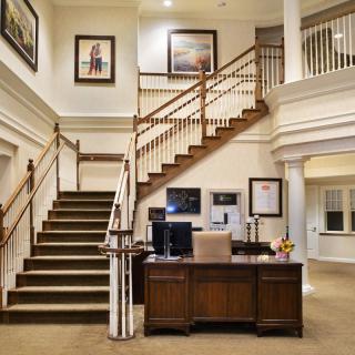 A traditional office space featuring a central staircase and reception desk.