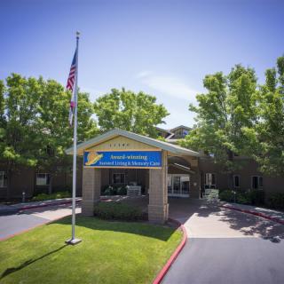 Entrance of a building with an American flag and surrounding trees.