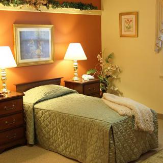A cozy bedroom with a single bed, warm lighting from lamps, and decorative elements.