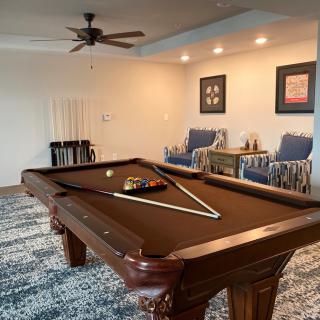 A cozy game room featuring a pool table and comfortable seating arrangements.