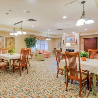 A cozy dining area with wooden tables and chairs, warm lighting, and elegant decor.