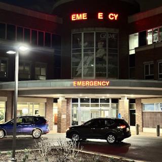 The entrance of a hospital's emergency department illuminated at night.