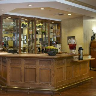 A hotel reception area with a wooden counter and refreshments.