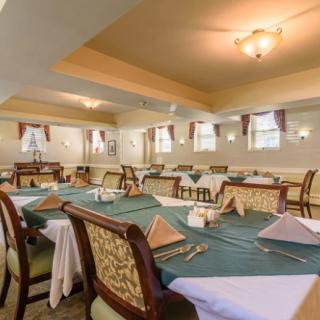 An elegantly set dining room with tables and chairs neatly arranged.