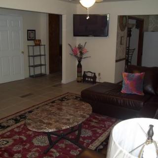 A cozy living room with a sofa, rug, and TV.