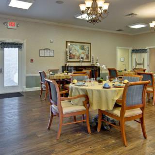 A cozy dining area with well-arranged tables and chairs, adorned with elegant decor.