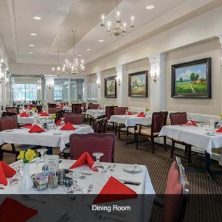 A well-decorated dining area with elegantly set tables and artwork on the walls.