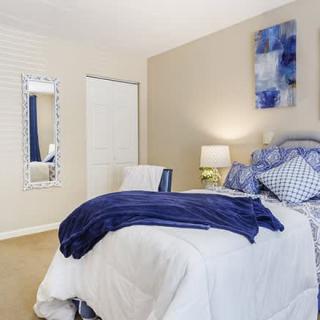 A cozy bedroom with blue accents and modern decor.