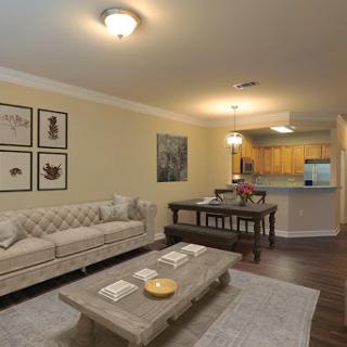 A stylish living room featuring a cozy sofa, elegant dining area, and tasteful artwork.