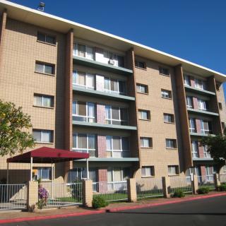 A multi-story apartment building with a brick exterior and balconies.