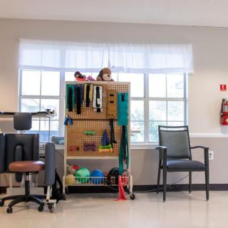 A therapy room equipped with exercise tools and seating for rehabilitation sessions.