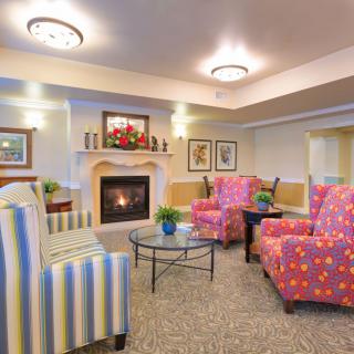 A cozy living room with a fireplace and colorful seating area.