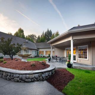 A spacious backyard with a patio and well-maintained landscaping.