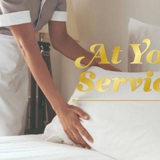 A housekeeping staff member making a bed, emphasizing quality service in hospitality.
