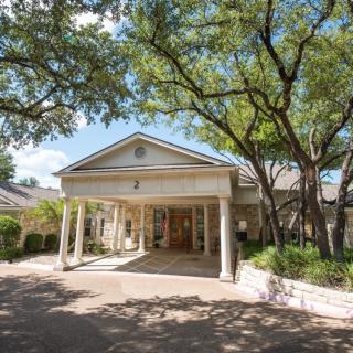 A classic building entrance surrounded by trees.