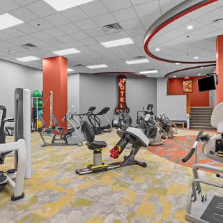 A modern gym with various exercise equipment and a spacious layout.