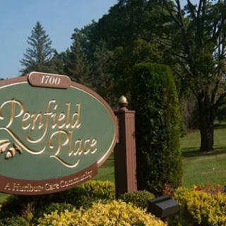 A welcoming park sign surrounded by lush greenery and trees.
