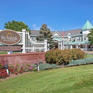 A nursing home with well-maintained landscaping and clear signage on a sunny day.