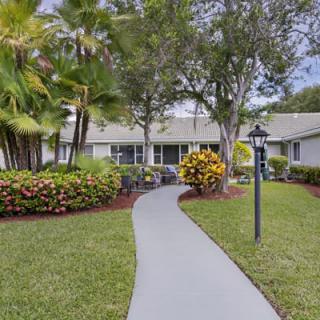 A suburban home with a landscaped front yard and a curved pathway leading to the entrance.