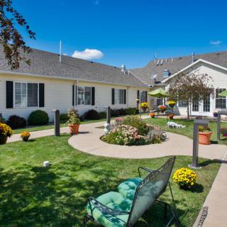 A well-maintained courtyard with lush landscaping and outdoor seating under a clear blue sky.