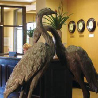 A decorative sculpture of two cranes displayed indoors.