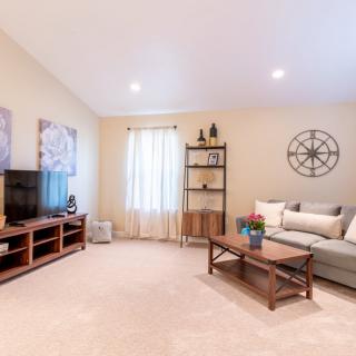 A cozy living room with a sofa, coffee table, television, and decorative elements.