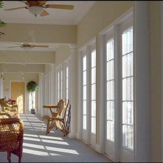 A bright sunroom with wicker furniture and French doors allowing natural light to fill the space.