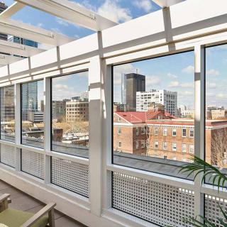 A sunlit room with large windows offering a panoramic view of the city skyline.