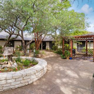 A serene residential courtyard with lush greenery and a welcoming pathway.